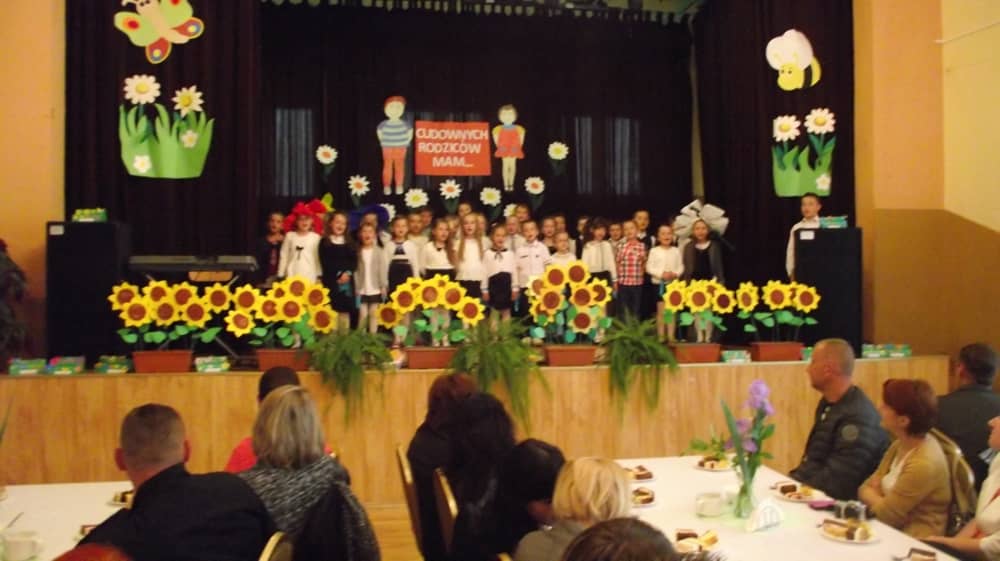 Grupa dzieci stojących na scenie.