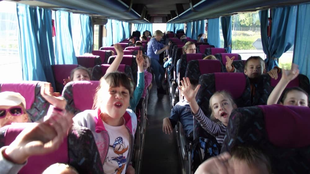 Dzieci siedzące na fotelach w autobusie.