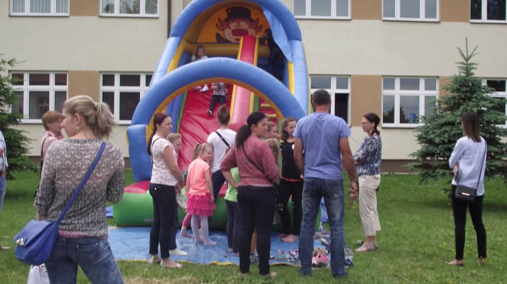 Ludzie czkający na wejście na dmuchaną zjeżdżalnię. 