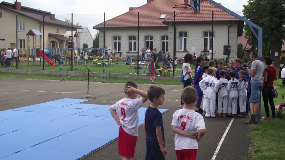 Dzieci stojące na szkolnym boisku.