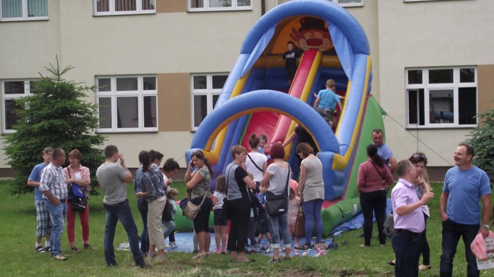 Ludzie czekający u podnóża dmuchanej zjeżdżalni. 