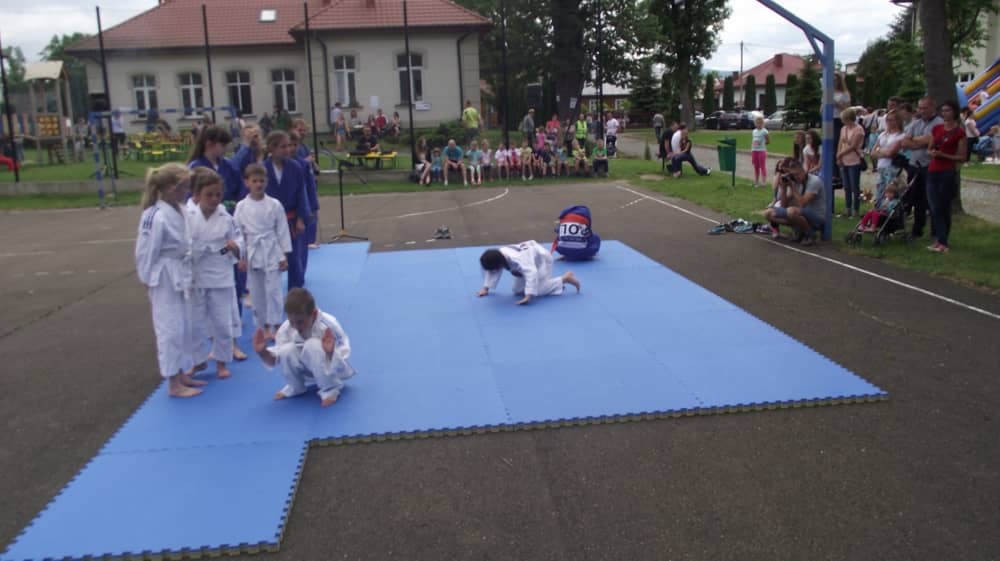 Dzieci turlające się po niebieskich materacach.