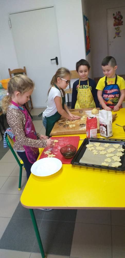 Dzieci wykrawające ciasteczka.